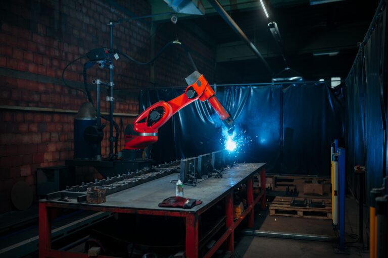 Industrial robotic arm performing automated arc welding in a manufacturing facility